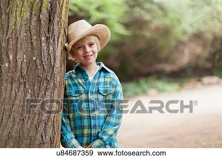 Stock Photo - Boy wearing cowboy hat outdoors. Fotosearch