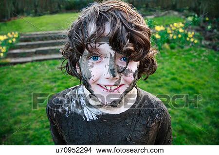 Picture - Boy's smiling face covered in mud. Fotosearch