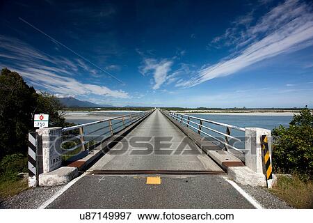 Bridge stretching over rural river View Large Photo Image Stock Photo - Bridge stretching over rural river. Fotosearch