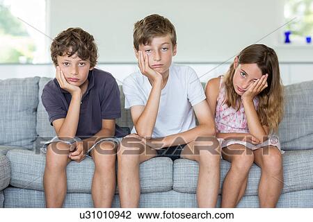 Brothers and sister on sofa looking bored View Large Photo Image Stock Image - Brothers and sister on sofa looking bored. Fotosearch