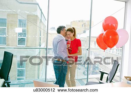 Stock Image - Business people flirting at office party. Fotosearch