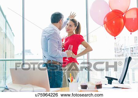 Stock Photograph - Business people flirting at office party. Fotosearch