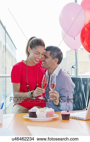Picture - Business people hugging at office party. Fotosearch