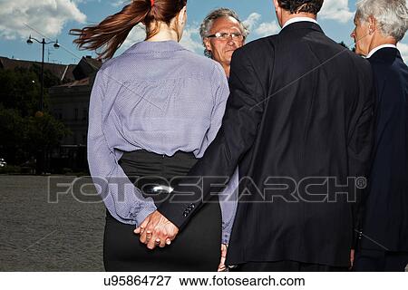 Business people secretly holding hands View Large Photo Image Stock Photo - Business people secretly holding hands. Fotosearch