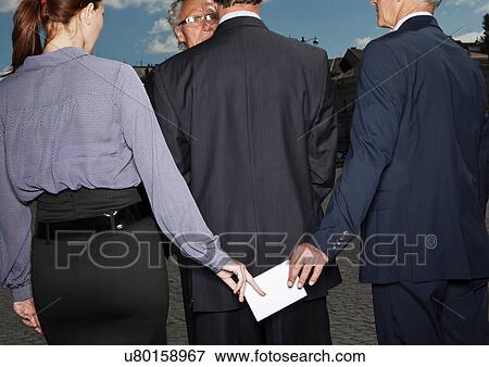 Business people secretly passing notes View Large Photo Image Stock Photo - Business people secretly passing notes. Fotosearch