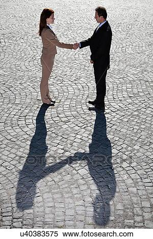 Stock Photography - Business people shaking hands outdoors. Fotosearch
