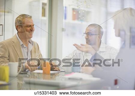 Stock Image - Business people talking in meeting. Fotosearch