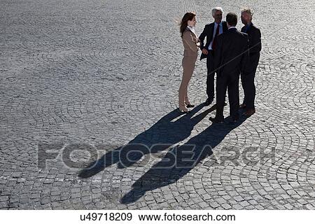 Business people talking on cobbled road View Large Photo Image Stock Photo - Business people talking on cobbled road. Fotosearch