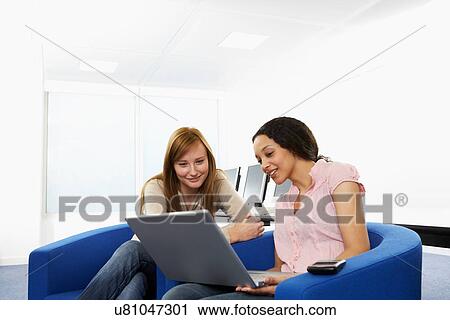 Stock Image - Business people using laptop in office. Fotosearch