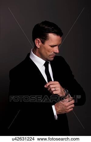 Businessman adjusting his cuffs View Large Photo Image Picture - Businessman adjusting his cuffs. Fotosearch