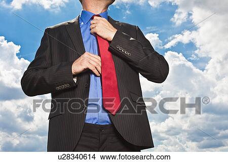 Picture - Businessman adjusting his tie. Fotosearch