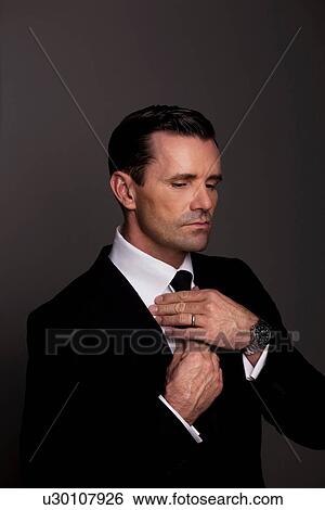 Stock Photograph - Businessman adjusting his tie. Fotosearch