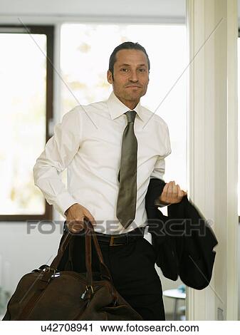 Businessman carrying luggage in hallway View Large Photo Image Stock Image - Businessman carrying luggage in hallway. Fotosearch