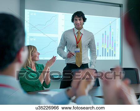 Businessman congratulated by colleagues in conference room for smart board presentation View Large Photo Image Stock Photograph - Businessman congratulated by colleagues in conference room for smart board presentation. Fotosearch