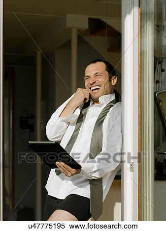 Businessman dressing and using tablet View Large Photo Image Stock Photography - Businessman dressing and using tablet. Fotosearch