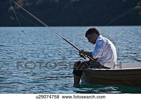Stock Photo - Businessman fishing in rowboat. Fotosearch