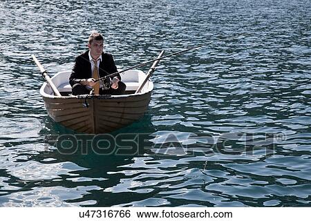 Businessman fishing in rowboat View Large Photo Image Stock Photograph - Businessman fishing in rowboat. Fotosearch