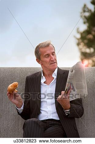 Businessman having breakfast outdoors View Large Photo Image Stock Image - Businessman having breakfast outdoors. Fotosearch