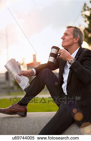 Stock Photography - Businessman having breakfast outdoors. Fotosearch