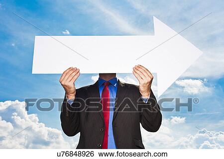 Stock Photograph - Businessman holding blank arrow. Fotosearch