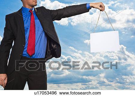 Stock Photograph - Businessman holding blank card. Fotosearch