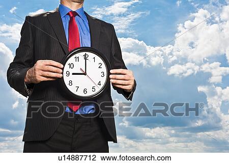 Businessman holding clock View Large Photo Image Stock Image - Businessman holding clock. Fotosearch
