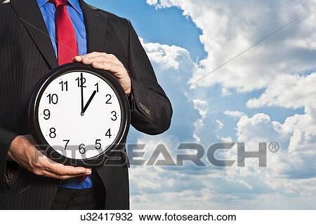 Businessman holding clock View Large Photo Image Stock Image - Businessman holding clock. Fotosearch