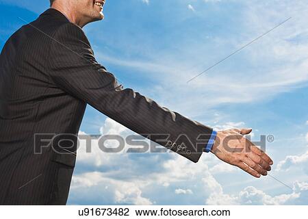 Stock Image - Businessman holding out hand to shake. Fotosearch