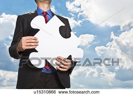 Businessman holding puzzle piece View Large Photo Image Stock Photograph - Businessman holding puzzle piece. Fotosearch