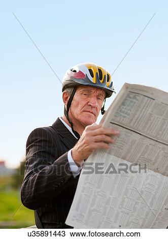 Businessman in bicycle helmet reading View Large Photo Image Stock Image - Businessman in bicycle helmet reading. Fotosearch