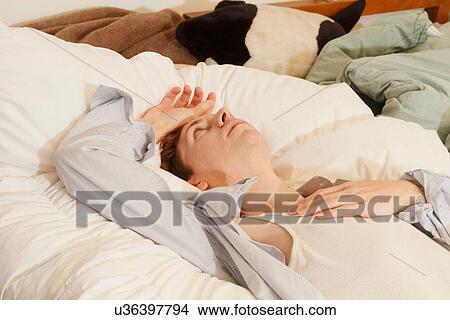 Businessman laying on bed View Large Photo Image Picture - Businessman laying on bed. Fotosearch