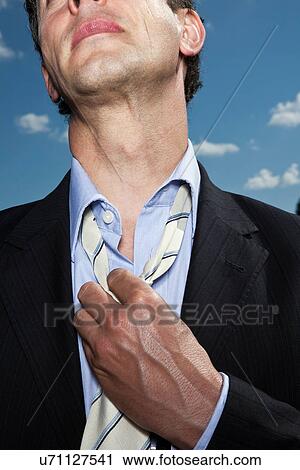 Businessman loosening his tie outdoors View Large Photo Image Stock Image - Businessman loosening his tie outdoors. Fotosearch