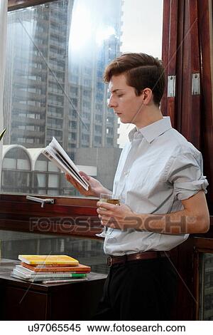 Businessman reading magazine with wine View Large Photo Image Stock Photography - Businessman reading magazine with wine. Fotosearch