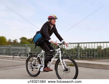 Businessman riding bicycle on bridge View Large Photo Image Picture - Businessman riding bicycle on bridge. Fotosearch