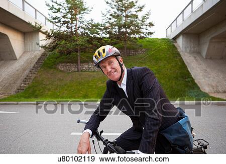 Businessman riding bicycle on street View Large Photo Image Stock Photo - Businessman riding bicycle on street. Fotosearch