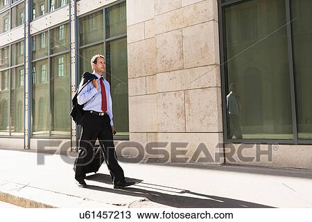 Businessman rolling luggage outdoors View Large Photo Image Stock Image - Businessman rolling luggage outdoors. Fotosearch