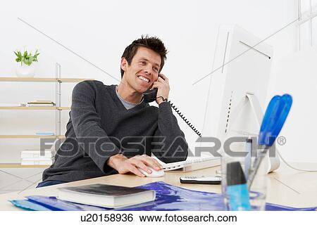 Stock Photograph - Businessman talking on phone at work. Fotosearch