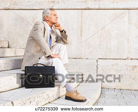 Stock Photo - Businessman thinking on stone steps. Fotosearch