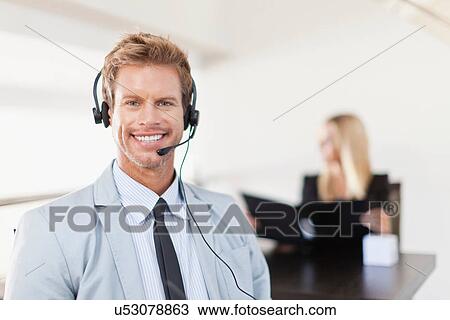 Businessman wearing headset at desk View Large Photo Image Stock Image - Businessman wearing headset at desk. Fotosearch