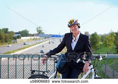 Businessman with bicycle on bridge View Large Photo Image Stock Image - Businessman with bicycle on bridge. Fotosearch