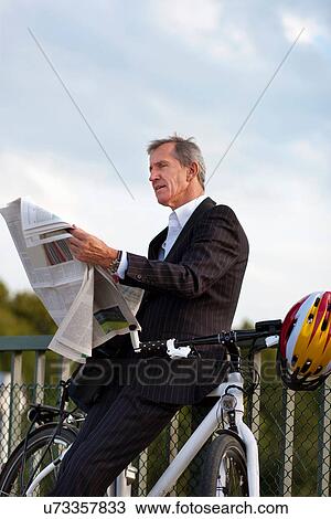 Businessman with bicycle reading View Large Photo Image Stock Image - Businessman with bicycle reading. Fotosearch