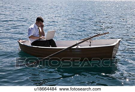 Picture - Businessman working in rowboat. Fotosearch