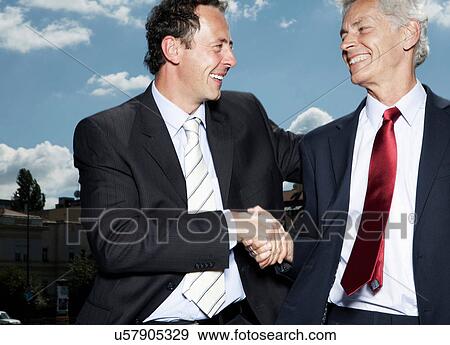 Businessmen shaking hands on rooftop View Large Photo Image Stock Photo - Businessmen shaking hands on rooftop. Fotosearch
