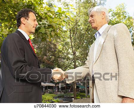 Businessmen shaking hands outdoors View Large Photo Image Stock Image - Businessmen shaking hands outdoors. Fotosearch