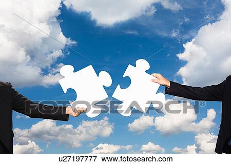 Businesspeople holding puzzle pieces View Large Photo Image Stock Photo - Businesspeople holding puzzle pieces. Fotosearch