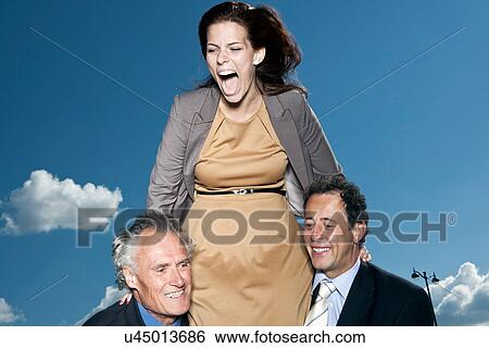 Stock Photograph - Businesswoman climbing on colleagues. Fotosearch