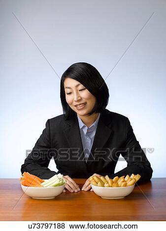 Businesswoman deciding what to eat View Large Photo Image Stock Photo - Businesswoman deciding what to eat. Fotosearch