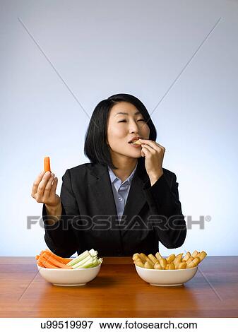 Stock Photo - Businesswoman deciding what to eat. Fotosearch