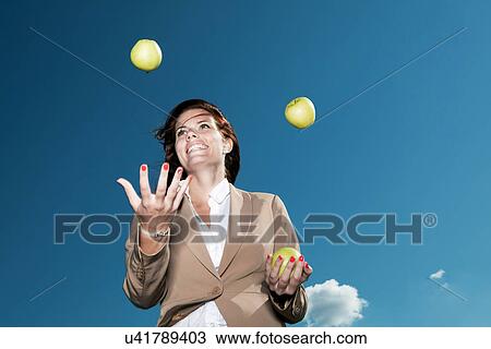 Businesswoman juggling apples outdoors View Large Photo Image Stock Image - Businesswoman juggling apples outdoors. Fotosearch