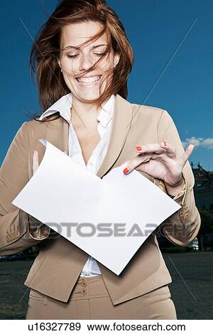 Stock Photo - Businesswoman ripping paper outdoors. Fotosearch